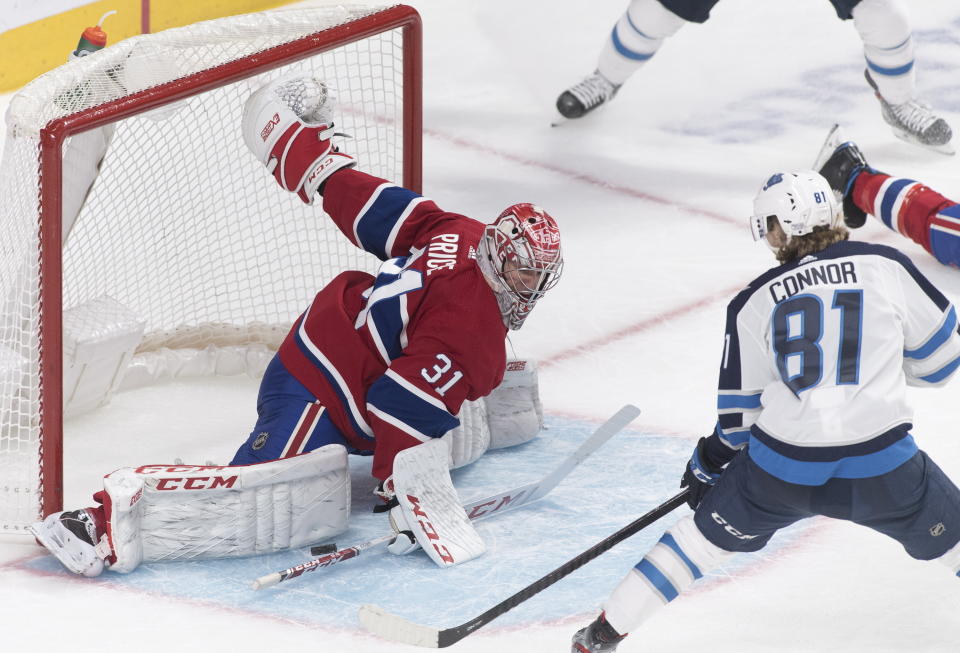 Montreal Canadiens goaltender Carey Price, left, makes a save against Winnipeg Jets' Kyle Connor during second-period NHL hockey game action in Montreal, Monday, Jan. 6, 2020. (Graham Hughes/The Canadian Press via AP)