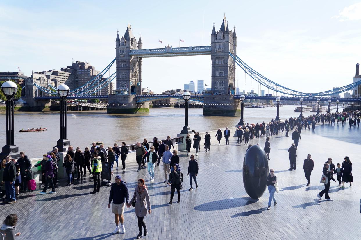 Members of the public line up near Tower Bridge as they wait to view Queen Elizabeth II's lying in state ahead of her funeral on Monday, in London, Saturday, Sept. 17, 2022. (James Manning/PA via AP)