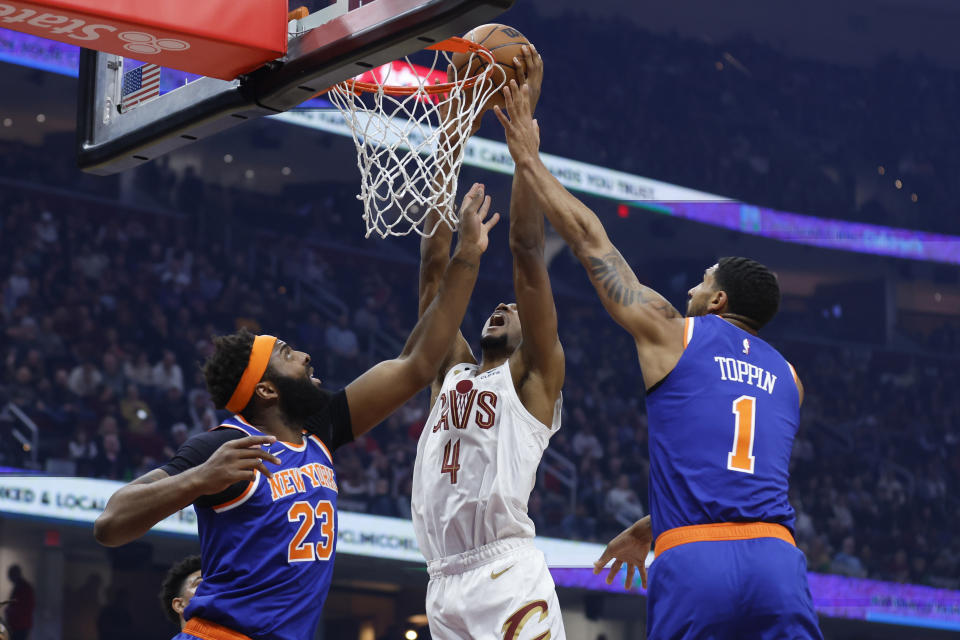 Cleveland Cavaliers forward Evan Mobley (4) shoots against New York Knicks center Mitchell Robinson (23) and forward Obi Toppin (1) during first half of an NBA basketball game Friday, March 31, 2023, in Cleveland. (AP Photo/Ron Schwane)