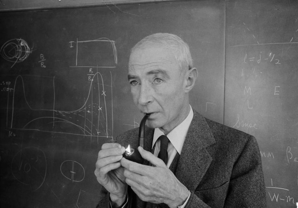 Dr. J. Robert Oppenheimer, creator of the atom bomb, lights his pipe as he stands in front of a blackboard in his office at the Institute for Advanced Study at Princeton, N.J., April 5, 1963. 