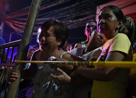 A relative of a victim cries behind the police line at the site of a drug-related shooting by unidentified men riding on motorcycles at Navotas City in metro Manila, Philippines June 19, 2017. REUTERS/Dondi Tawatao