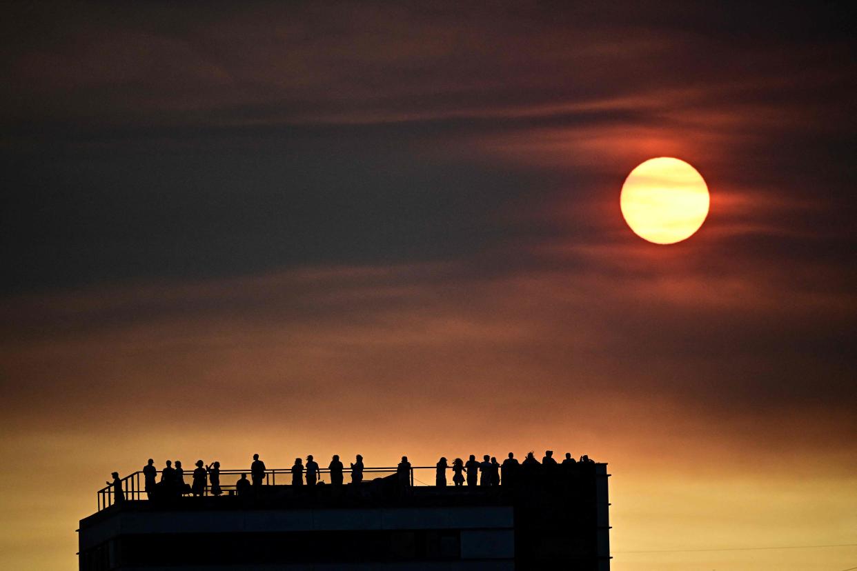 The sun goes down behind smoke from wildfires in Tejo Park, Lisbon on 5 August (AFP via Getty Images)