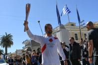 US actor Gerard Butler takes part in the Olympic flame torch relay for the Tokyo 2020 Summer Olympics