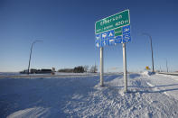 Road signage is posted just outside of Emerson, Manitoba on Thursday, Jan. 20, 2022. A Florida man was charged Thursday with human smuggling after the bodies of four people, including a baby and a teen, were found in Canada near the U.S. border, in what authorities believe was a failed crossing attempt during a freezing blizzard. The bodies were found Wednesday in the province of Manitoba just meters (yards) from the U.S. border near the community of Emerson. (John Woods/The Canadian Press via AP)