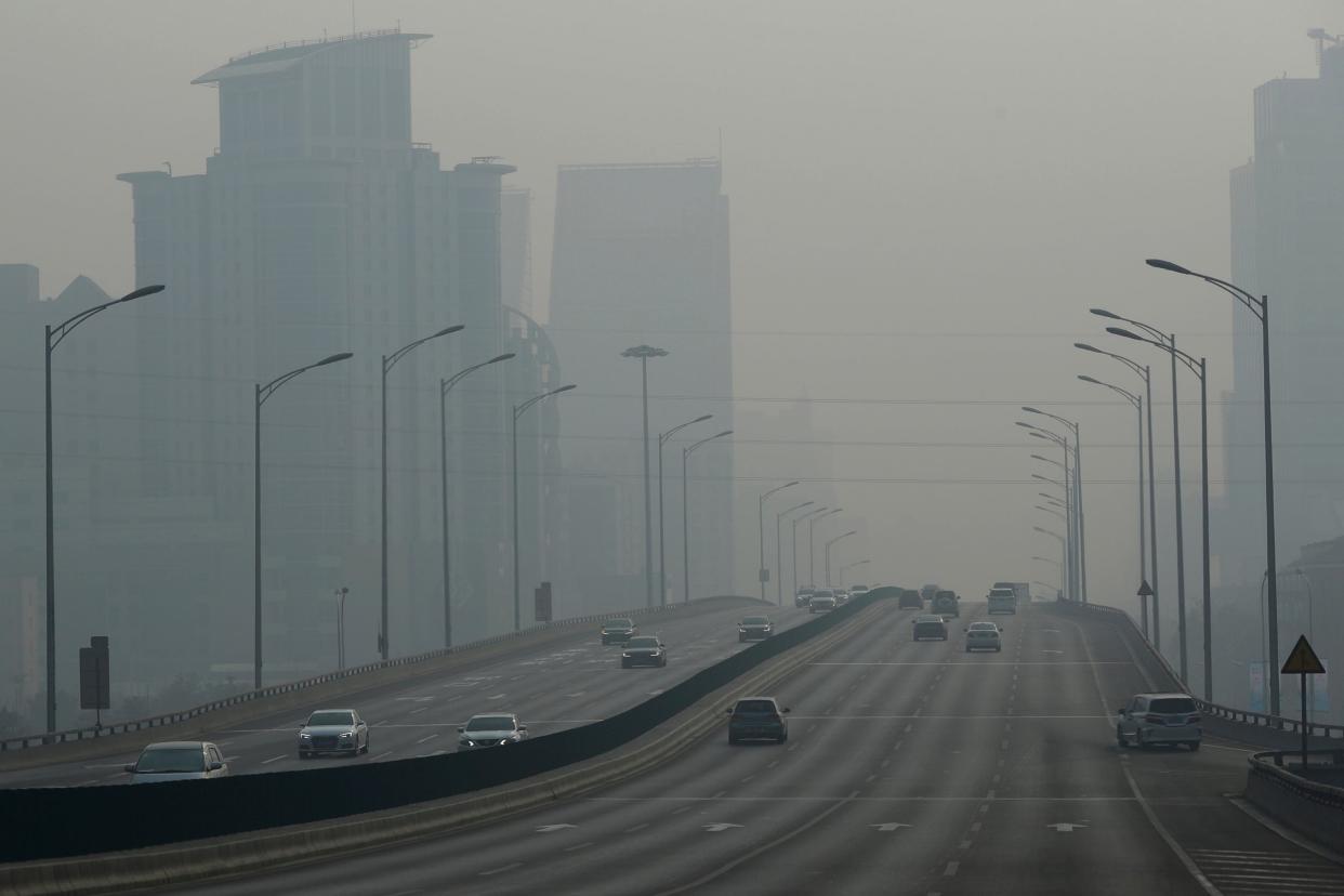 Vehicles travel on a main road as air pollution reduces visability in Beijing: EPA