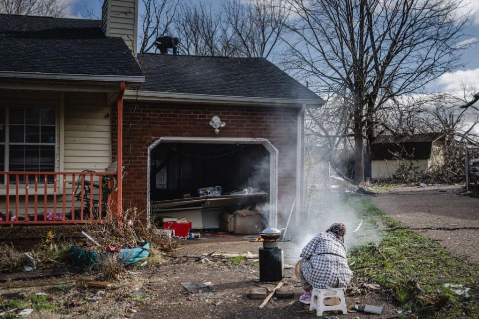 A resident cooks food in their driveway in the aftermath of a tornado on Dec. 10, 2023, in Madison, Tennessee.