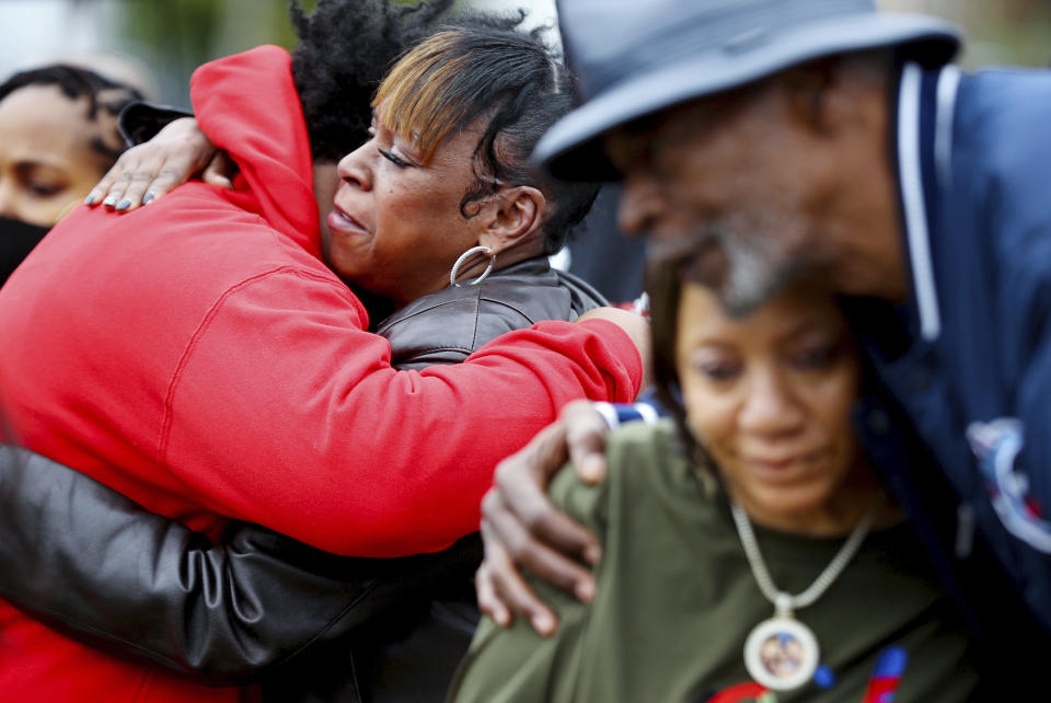 Friends and family of slain rapper, Young Dolph, hug after a street naming ceremony honoring Young Dolph in Memphis, Tenn., Wednesday, Dec. 15, 2021. Family and friends of slain rapper Young Dolph have remembered him as a generous philanthropist, skilled businessman and loving father at a ceremony renaming a street for him in the same area of Memphis where he grew up — and also was gunned down. (Patrick Lantrip/Daily Memphian via AP)