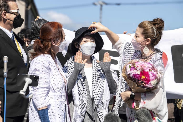 Japan’s Red Army founder Fusako Shigenobu (C) after her release from jail, flanked by her daughter May Shigenobu (R) and her lawyer (L) talks to journalists in Akishima, Tokyo prefecture on May 28, 2022. (Photo by Charly TRIBALLEAU / AFP)