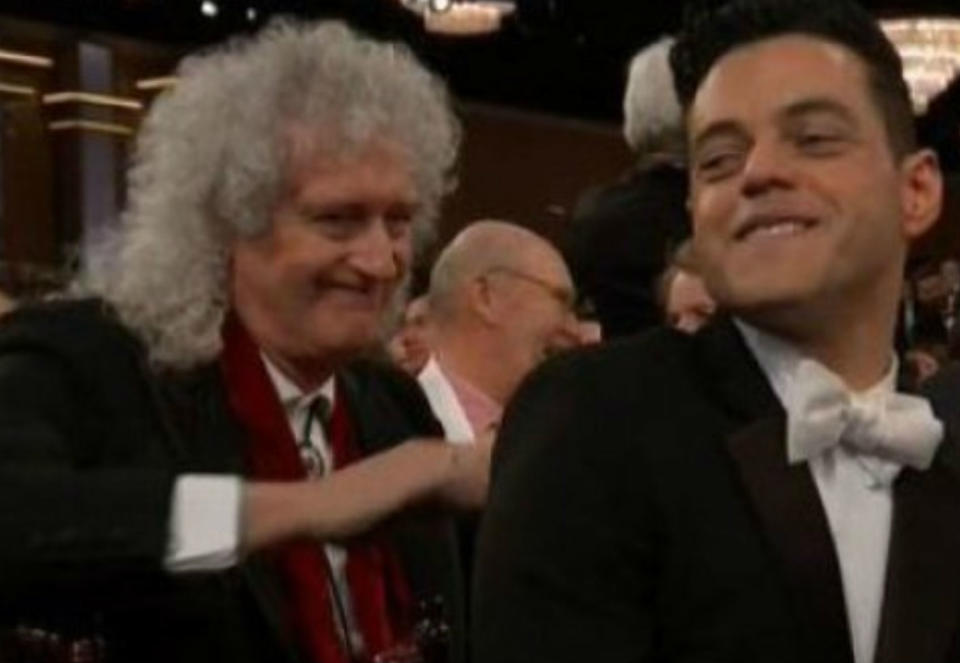 <p>Rami Malek sí que estaba contento al recibir su premio, aunque no sabemos si le hizo demasiada gracia que Brian May no dejara de darle palmaditas en la espalda mientras se levantaba a recoger su galardón. (Foto: NBC). </p>