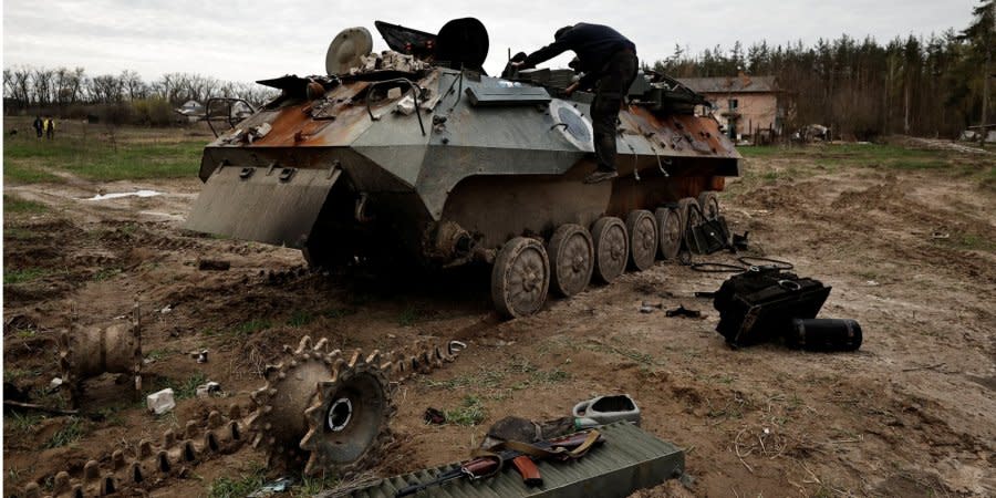 A Ukrainian soldier examines a captured Russian armored vehicle.