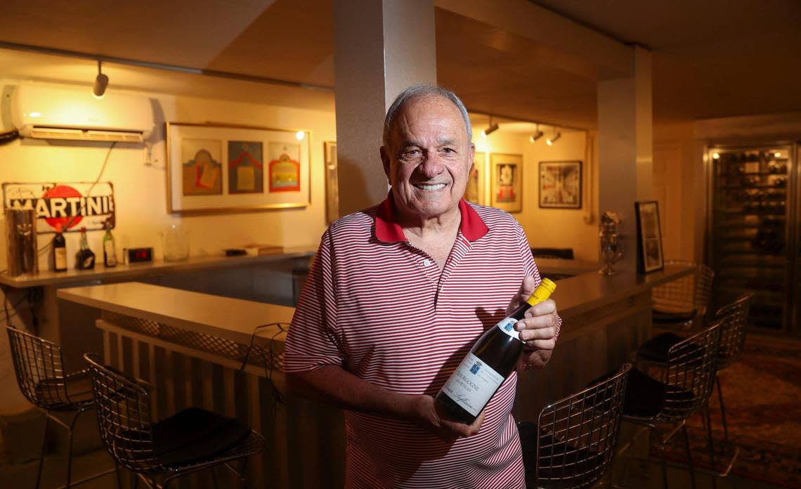 Attorney A.J. Barranco shows off a bottle from his wine collection, which he stores in a former bomb shelter dug into the limestone bluff beneath his house.