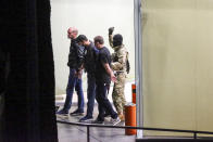 A gunman with a weapon in hand, escorts three police officers, who surrendered themselves as hostages, out of the bank building in the town of Zugdidi in western Georgia, Wednesday, Oct. 21, 2020. Authorities in the ex-Soviet republic of Georgia say an armed assailant has taken hostages at a bank. Local media reported that up to 19 hostages could be inside the bank. The Georgian Interior Ministry didn't immediately comment on how many people were taken hostage Wednesday in the western town of Zugdidi or what demands their captor had made. (AP Photo/Zurab Tsertsvadze)