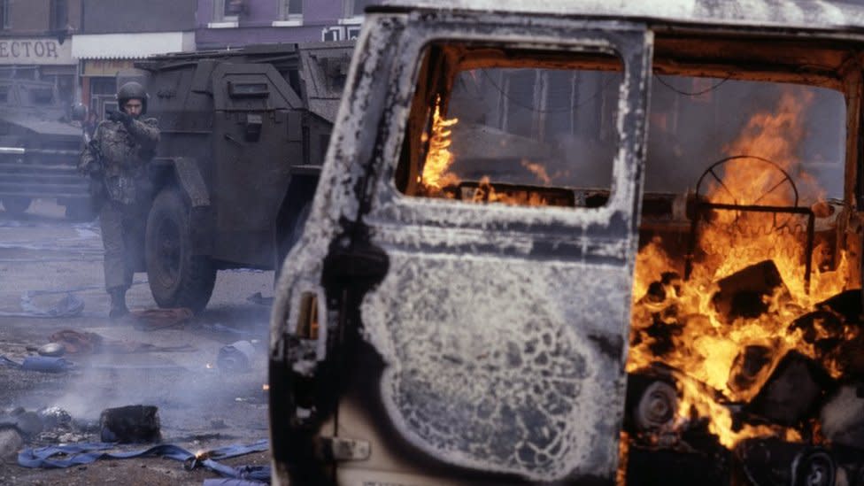 A vehicle burning on a Belfast street circa 1980