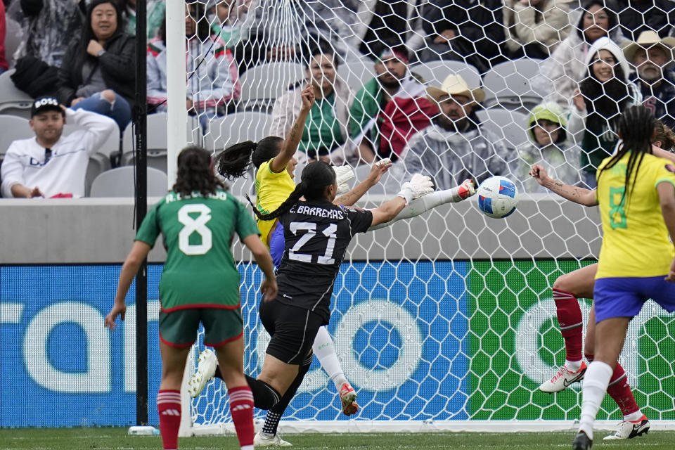 Brazil's Adriana, second from left, scores a goal as Mexico goalkeeper Esthefanny Barreras (21) tries to deflect during the first half of a CONCACAF Gold Cup women's soccer tournament semifinal match, Wednesday, March 6, 2024, in San Diego. (AP Photo/Gregory Bull)