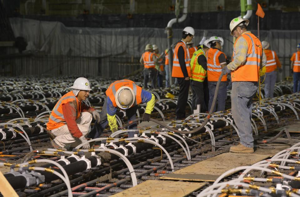 Crews pour concrete to lay the foundation for the New Wilshire Grand building in a record attempt for the largest continuous concrete pour in history, Saturday, Feb. 15, 2014, in downtown Los Angeles. The marathon pour is expected to last 20 hours without interruption. The attempt will be verified by an official from Guinness World Records. The New Wilshire Grand will be the tallest building to be built west of the Mississippi and is expected to be completed in 2017. (AP Photo/Mark J. Terrill)