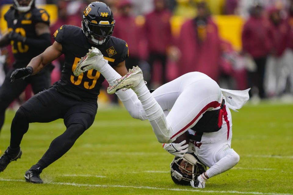 Atlanta Falcons wide receiver Drake London (5) flips over as he avoids getting hit by Washington Commanders linebacker Jon Bostic (59) during the first half of an NFL football game, Sunday, Nov. 27, 2022, in Landover, Md. (AP Photo/Alex Brandon)