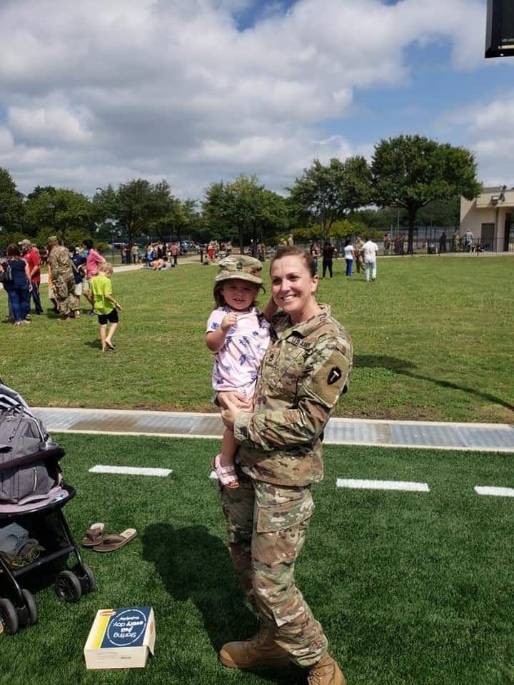 National Guard Sgt. Nicole Tinker holds her then 1-year-old daughter at a spring family day at Camp Mabry in West Austin.