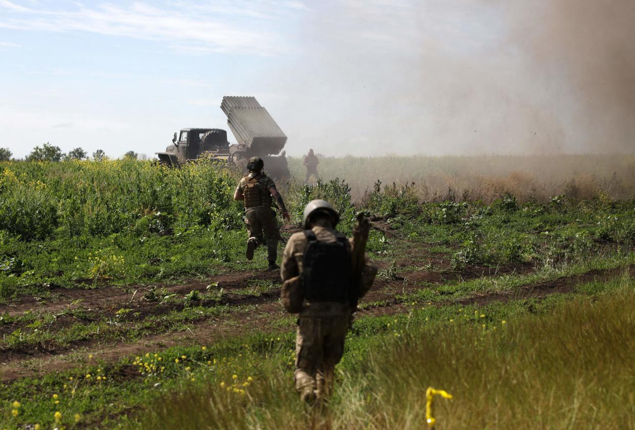 Ukrainian servicemen shift position after firing rockets (AFP via Getty Images)