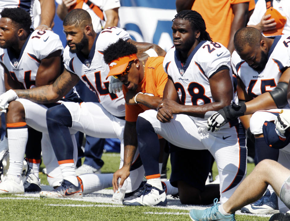 Broncos players, including Jamaal Charles (28) kneel during the national anthem prior to a Week 3 game. (AP)