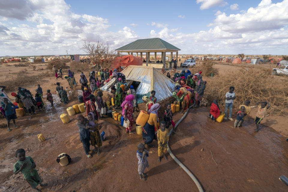 Water is distributed at a camp for displaced people on the outskirts of Dollow, Somalia on Tuesday, Sept. 20, 2022. Somalia is in the midst of the worst drought anyone there can remember. A rare famine declaration could be made within weeks. Climate change and fallout from the war in Ukraine are in part to blame. (AP Photo/Jerome Delay)