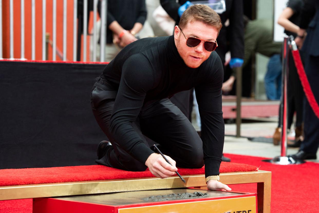 Boxer Canelo Alvarez signs the ciment at his Hand and Footprint Ceremony at TCL Chinese Theatre, in Hollywood, California, March 20, 2021. (Photo by VALERIE MACON / AFP) (Photo by VALERIE MACON/AFP via Getty Images)