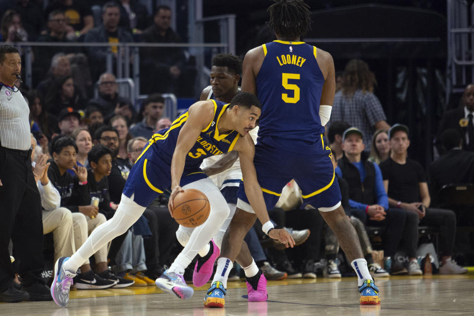 Golden State Warriors guard Jordan Poole (3) beats Minnesota Timberwolves guard Anthony Edwards around a pick set by Kevon Looney (5) during the first quarter of an NBA basketball game, Sunday, March 26, 2023, in San Francisco. (AP Photo/D. Ross Cameron)