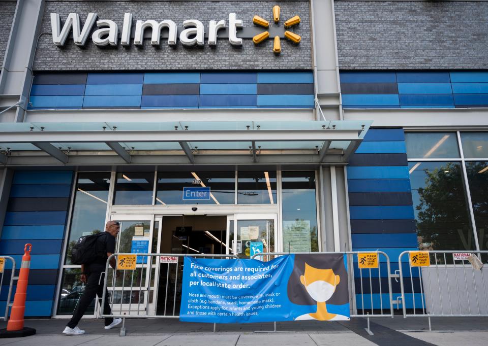 A man walks near a sign informing customers that face coverings are required in front of a Walmart store in Washington, DC on July 15, 2020. - Walmart will require shoppers to wear face masks starting next week, the US retail giant announced on July 15, joining an increasing number of businesses in mandating the protection amid the latest spike in coronavirus cases. (Photo by ANDREW CABALLERO-REYNOLDS / AFP) (Photo by ANDREW CABALLERO-REYNOLDS/AFP via Getty Images)