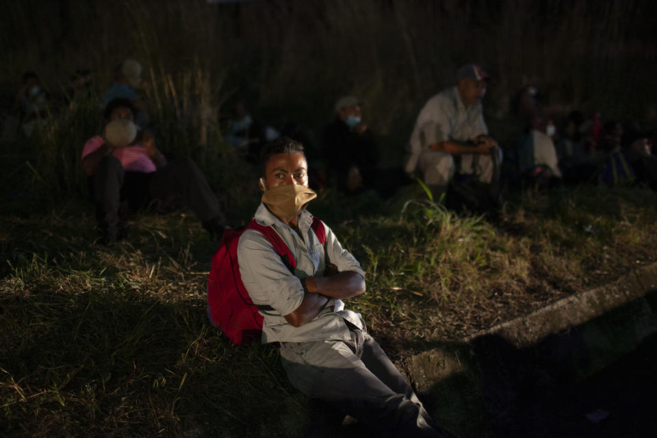 Honduran migrants hoping to reach the U.S. border rest on the side of a highway as soldiers patrol the road in Vado Hondo, Guatemala, Saturday, Jan. 16, 2021. Guatemalan authorities estimated that as many as 9,000 Honduran migrants crossed into Guatemala as part of an effort to form a new caravan to reach the U.S. border. (AP Photo/Sandra Sebastian)