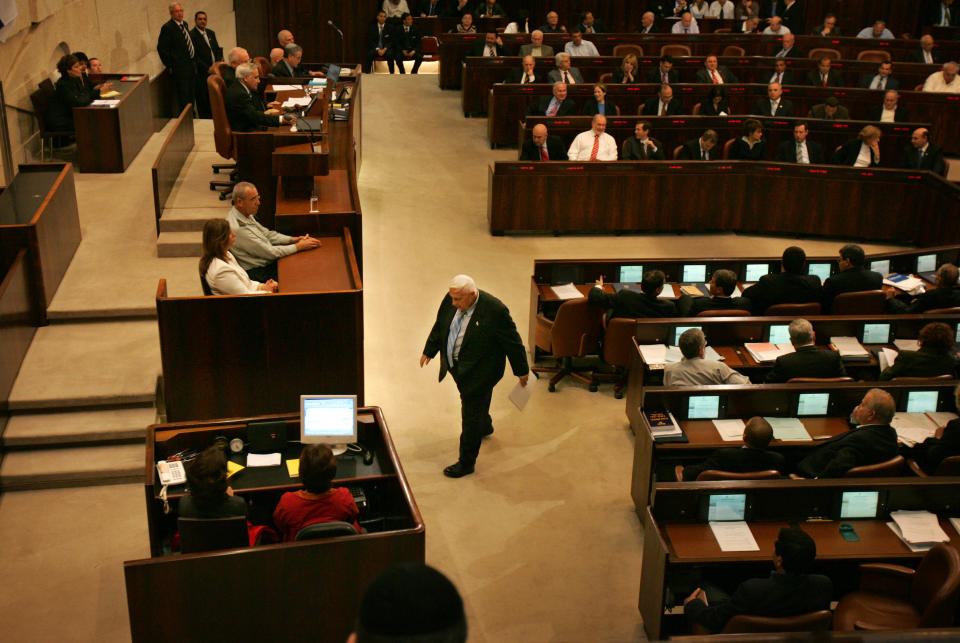 FILE - In this Monday, Oct. 31, 2005 file photo, Israeli Prime Minister Ariel Sharon walks before delivering a speech at the opening of the winter session of the Knesset, Israel's parliament, in Jerusalem. The son of former Israeli Prime Minister Ariel Sharon says his father has died on Saturday, Jan. 11, 2014. The 85-year-old Sharon had been in a coma since a debilitating stroke eight years ago. His son Gilad Sharon said: "He has gone. He went when he decided to go." (AP Photo/Oded Balilty, File)