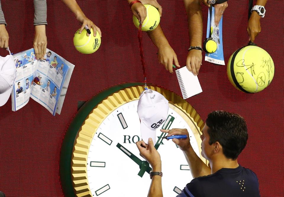 Canada's Raonic signs autographs after winning his quarter-final match against France's Monfils at the Australian Open tennis tournament at Melbourne Park