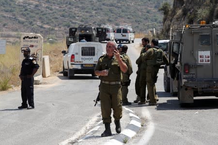 Israeli forces gather at the scene of an attack near the Jewish settlement of Dolev in the Israeli-occupied West Bank
