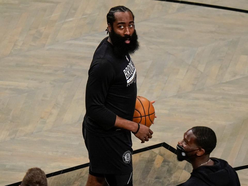 Kevin Durant holds a basketball and looks up at the basket during warmups before a game in 2022.