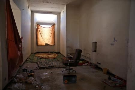 Rugs, a chair and an empty box of ammunition are seen inside a room at a railway station in western Mosul, Iraq, April 10, 2017. REUTERS/Andres Martinez Casares/Files