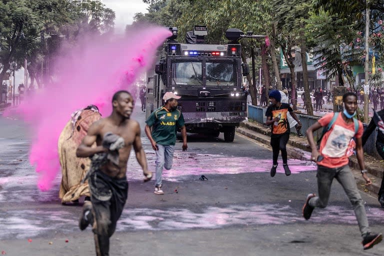 Los manifestantes corren para refugiarse mientras un camión con cañón de agua de la policía de Kenia les arroja agua mientras se manifestaban durante una huelga nacional para protestar contra los aumentos de impuestos y el Proyecto de Ley de Finanzas 2024 en el centro de Nairobi, el 25 de junio de 2024