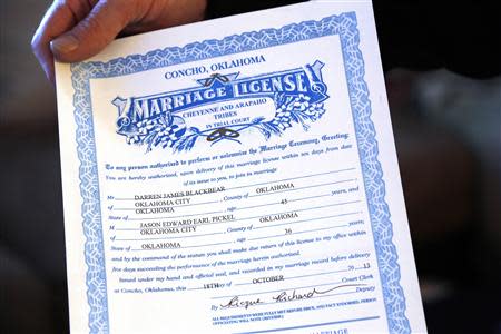Jason Pickel holds his marriage license to Darren Black Bear before being married by Darren's father Rev. Floyd Black Bear in El Reno, Oklahoma October 31, 2013. REUTERS/Rick Wilking