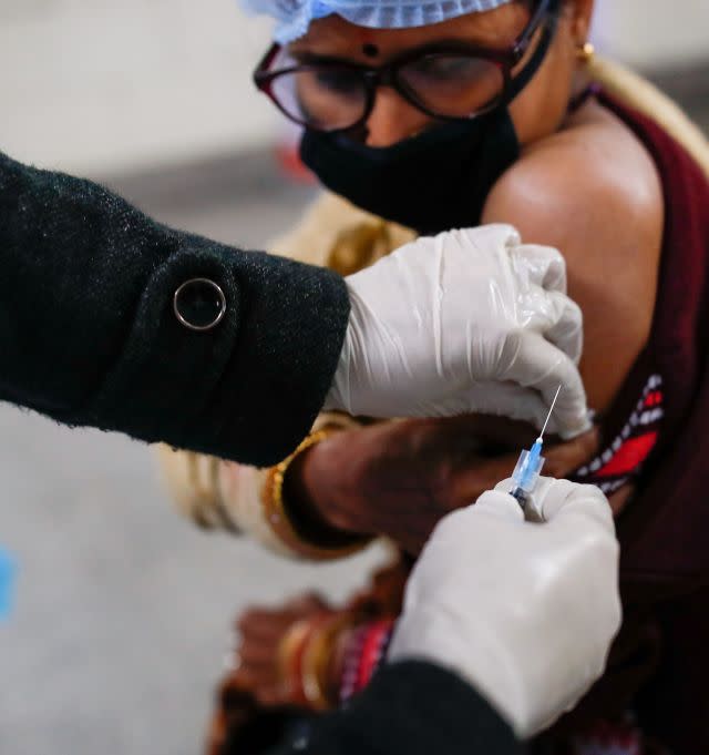 A health worker and a volunteer take part in a nationwide trial run of coronavirus vaccine delivery systems, in a school in New Delhi