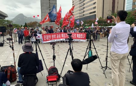 Mobile phones for a live broadcast film members of a conservative civic group taking part in a protest in Seoul