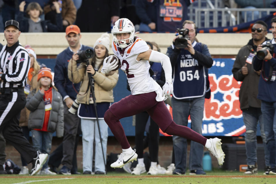 Virginia Tech running back Bryce Duke (22) runs for a touchdown against Virginia during the first half of an NCAA college football game Saturday, Nov. 25, 2023, in Charlottesville, Va. (AP Photo/Mike Caudill)