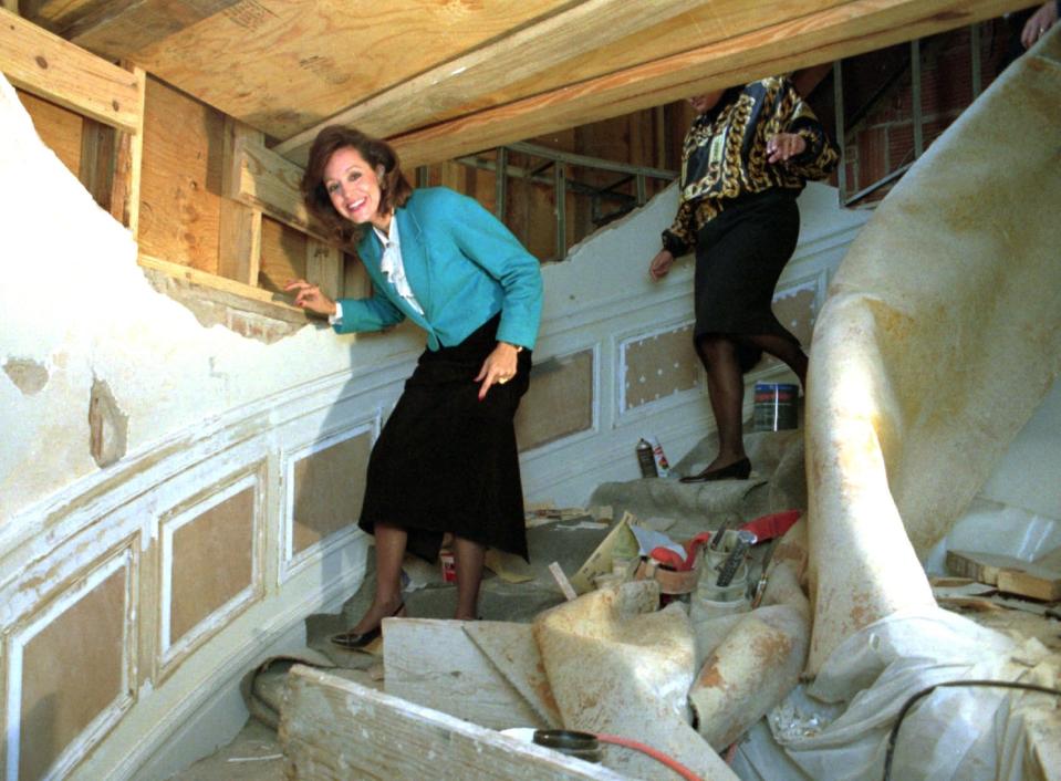 Former first lady Cathy Keating, who led a major renovation of the Governor's Mansion and formed the private foundation to fund improvements, is shown here in a 1995 photo ducking under scaffolding on the mansion stairs.