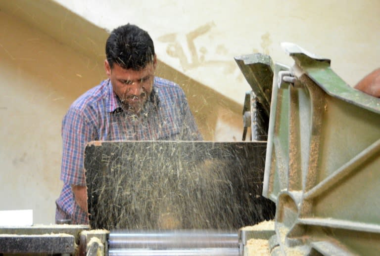 Yussef al-Qabuni trims a piece of wood at his workshop