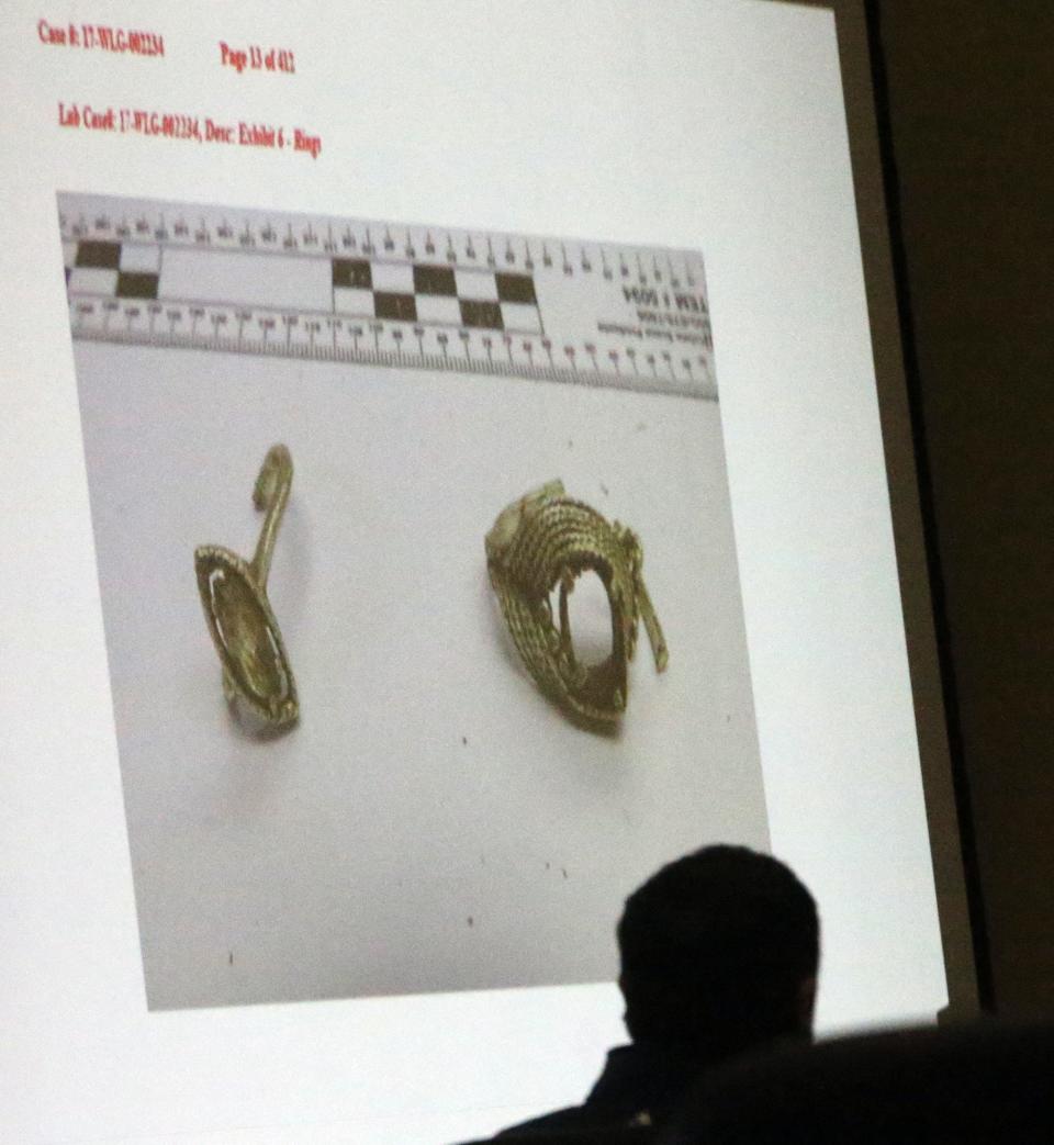 Defendant Timothy Verrill is silhouetted against images of rings once worn by murder victim Christine Sullivan which were tested for DNA samples and discussed during Verrill's trial in Strafford County Superior Court in Dover Tuesday, April 2, 2024.