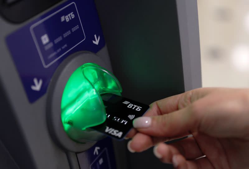 An employee demonstrates a payment card at a branch of VTB bank in Moscow