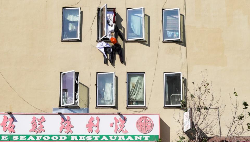 Various windows outside a Chinatown single-room-occupancy hotel in downtown San Francisco. People who live in SRO's have communal bathrooms and kitchens, and often families have to share a space little bigger than a prison cell. Such tight quarters draw alarm during the pandemic, which spreads easily from person to person.