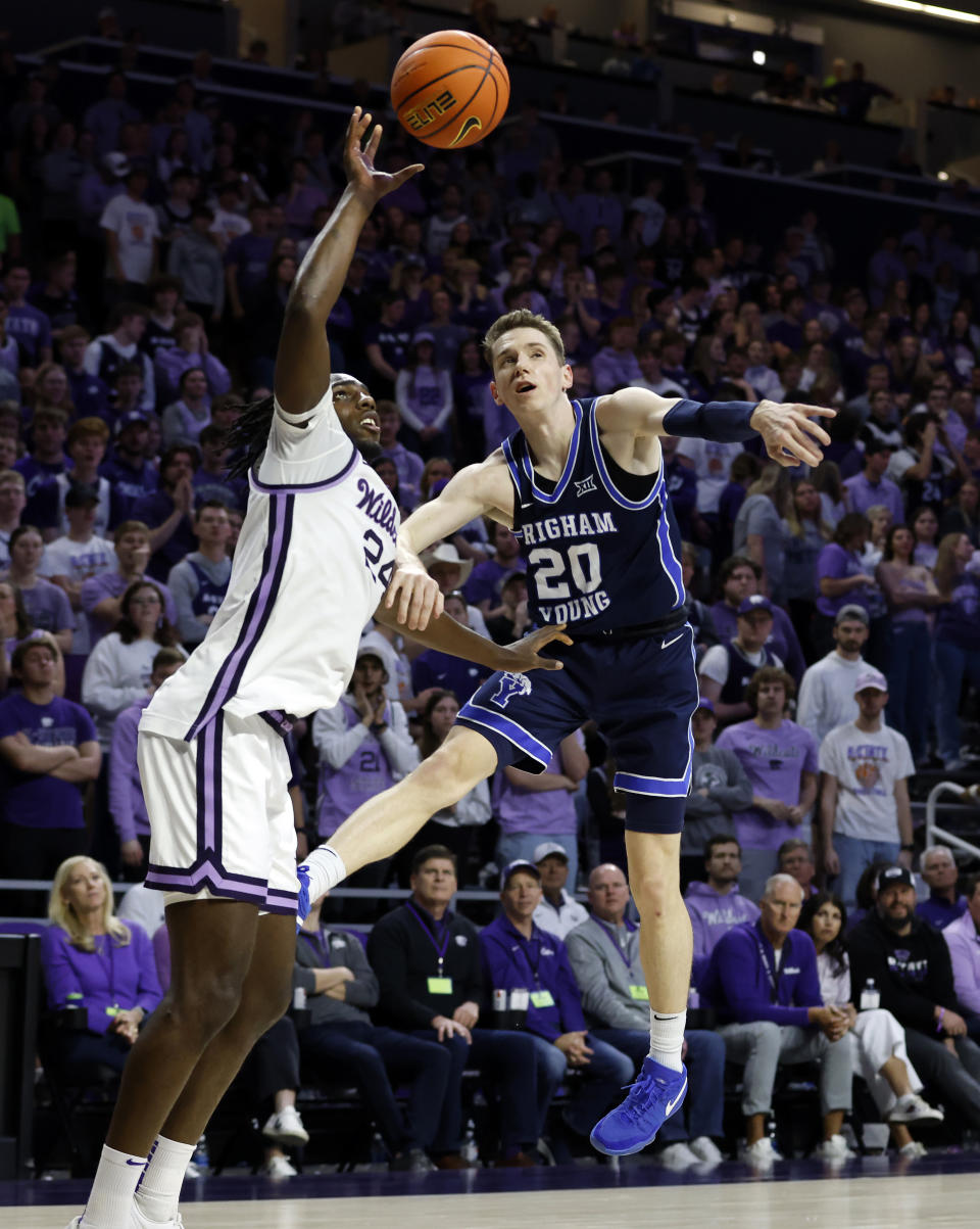 BYU guard Spencer Johnson (20) attempts to steal a pass from Kansas State forward Arthur Kaluma (24) during the first half of an NCAA college basketball game, Saturday, Feb. 24, 2024, in Manhattan, Kan. (AP Photo/Colin E. Braley)