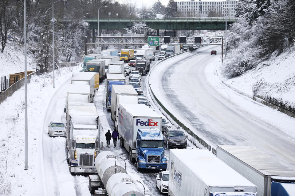 The backup of cars and trucks stuck on Interstate 84 is seen from the Blumenauer Bicycle and Pedestrian Bridge in Northeast Portland, Ore., Thursday,  Feb. 23, 2023. Nearly a foot of snow fell in Portland on Wednesday. (Dave Killen / The Oregonian via AP)