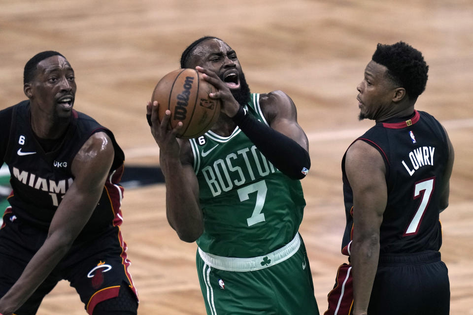 Boston Celtics guard Jaylen Brown, center, shoots as Miami Heat center Bam Adebayo left, and guard Kyle Lowry defend during the first half in Game 7 of the NBA basketball Eastern Conference finals Monday, May 29, 2023, in Boston. (AP Photo/Charles Krupa )