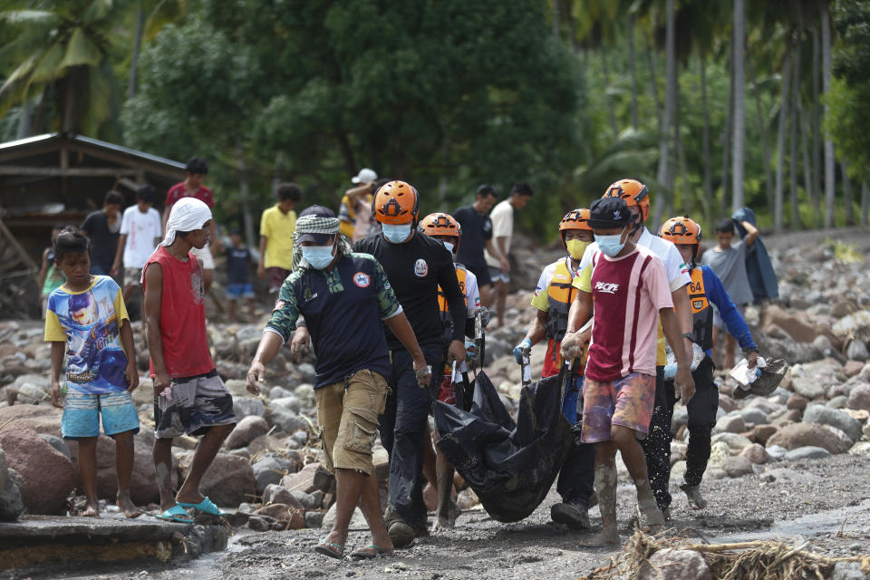 Rescuers carry a body which they retrieved after Tropical Storm Nalgae hit Maguindanao's Datu Odin Sinsuat town, southern Philippines on Saturday Oct. 29, 2022. Flash floods and landslides set off by torrential rains left dozens of people dead, including in a hard-hit southern Philippine province, where many villagers are feared missing and buried in a deluge of rainwater, mud, rocks and trees, officials said Saturday. (AP Photo)