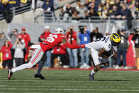 Michigan receiver Cornelius Johnson, right, escapes the grasp of Ohio State defensive back Cameron Brown during the first half of an NCAA college football game on Saturday, Nov. 26, 2022, in Columbus, Ohio. (AP Photo/Jay LaPrete)