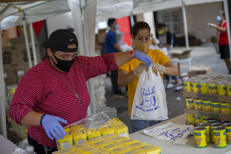 Voluntarios organizan bolsas de alimentos en un centro de apoyo comunitario en Caguas, Puerto Rico el 12 de junio de 2020. (Dennis M. Rivera Pichardo/The New York Times)