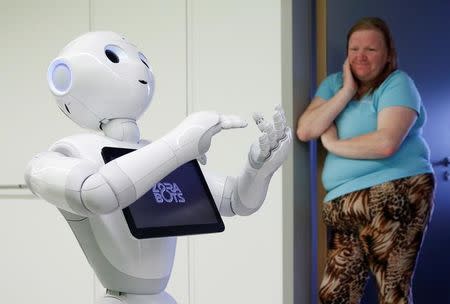 A visitor watches new recruit "Pepper" the robot, a humanoid robot designed to welcome and take care of visitors and patients, at AZ Damiaan hospital in Ostend, Belgium June 16, 2016. REUTERS/Francois Lenoir
